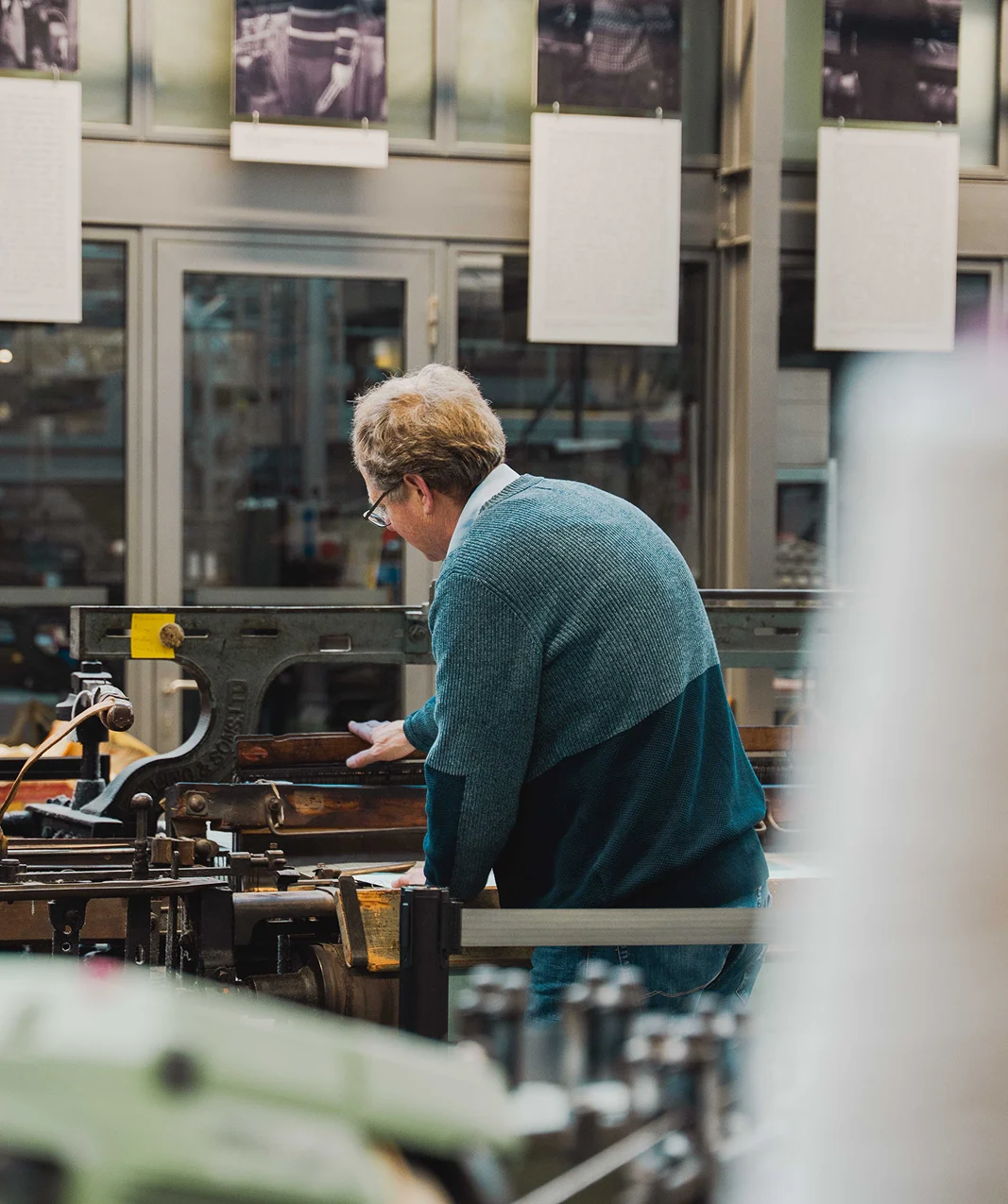 Medewerker van het Weverijmuseum aan het werk met een historische textielmachine