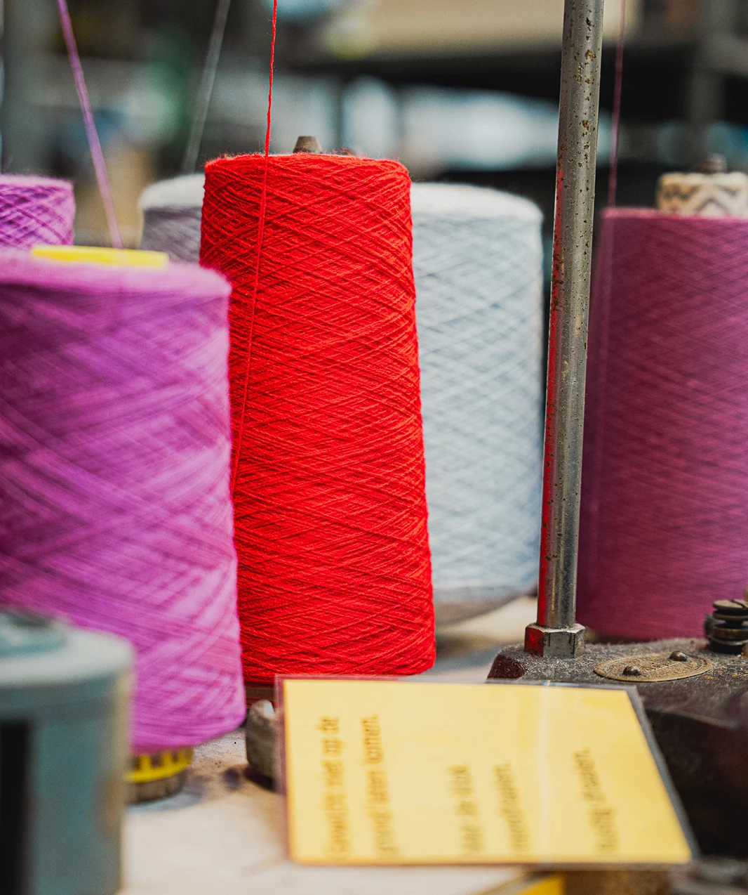 Rode, paarse en witte garenspoelen op een textielmachine
