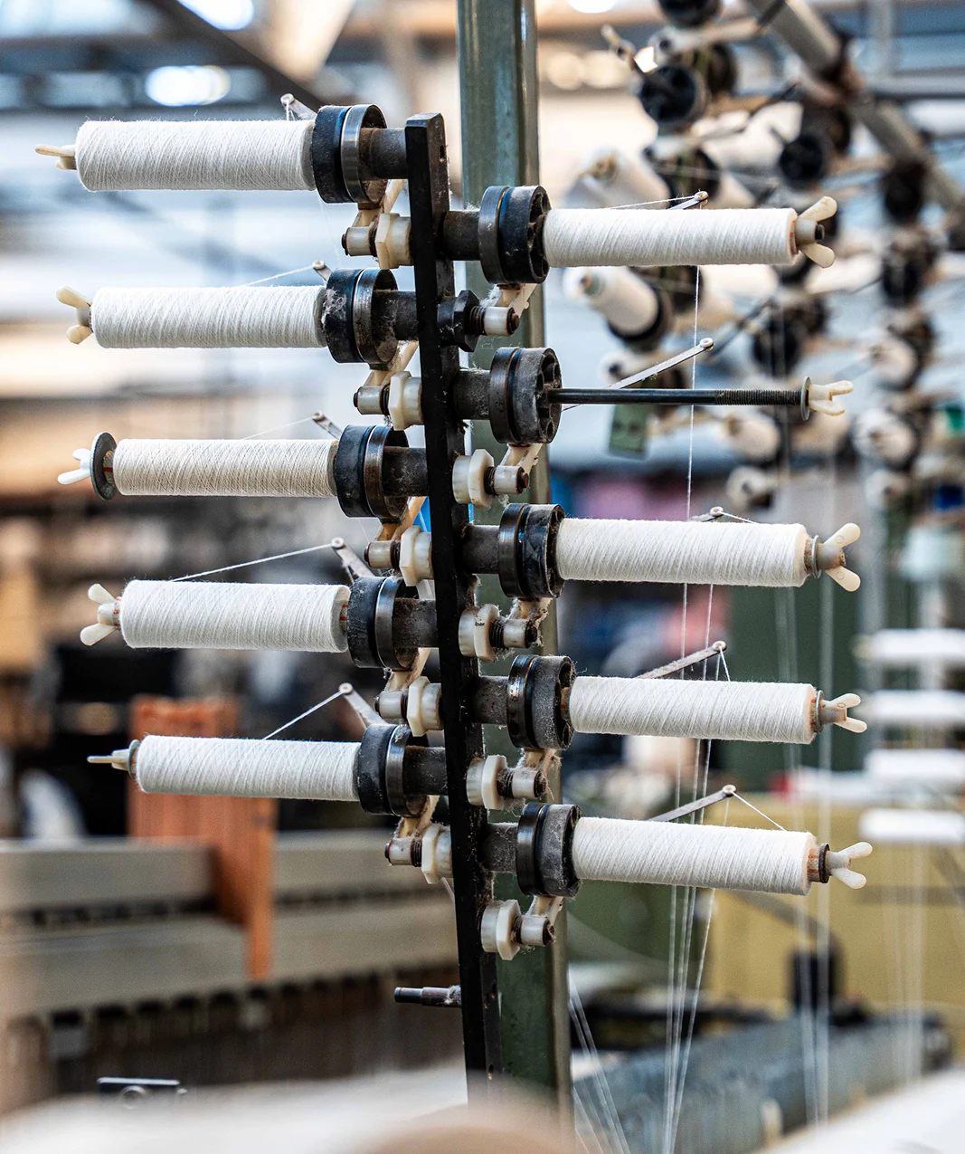 Witte garenspoelen op een historische textielmachine